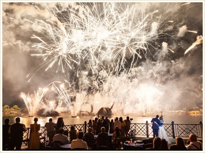 Ashleigh and her husband watching fireworks over the lagoon at Walt Disney World on their wedding night, guests seated around them